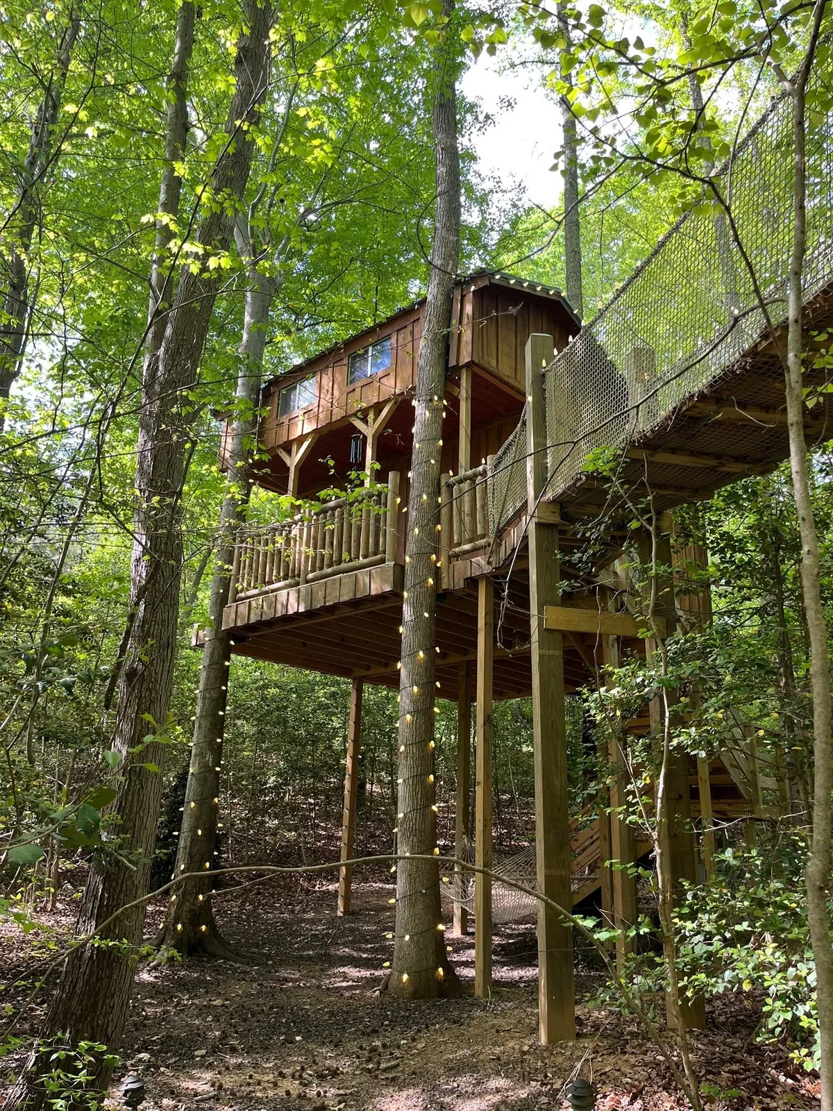 Elevated custom tree house with lighted rope-bridge walkway — TNT Construction, Maiden NC